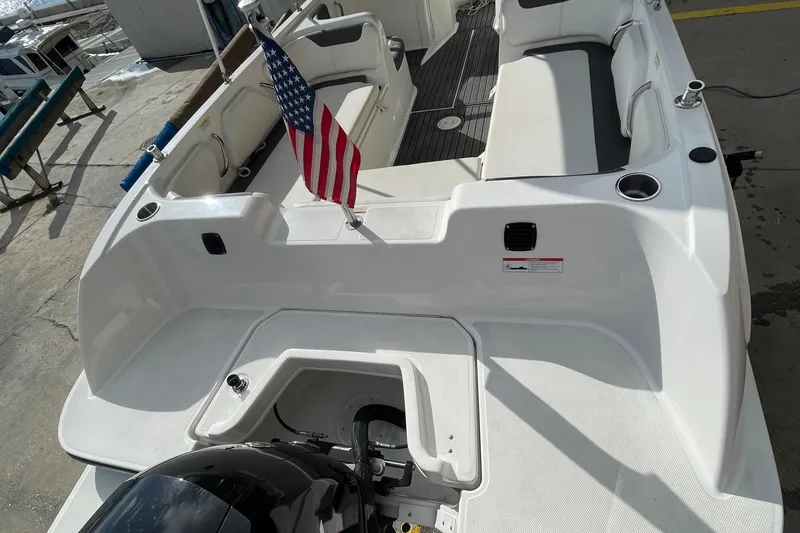 Slide: The Image of 2021 Bayliner Element E21 boat with American flag, spacious seating, and modern design. - 14