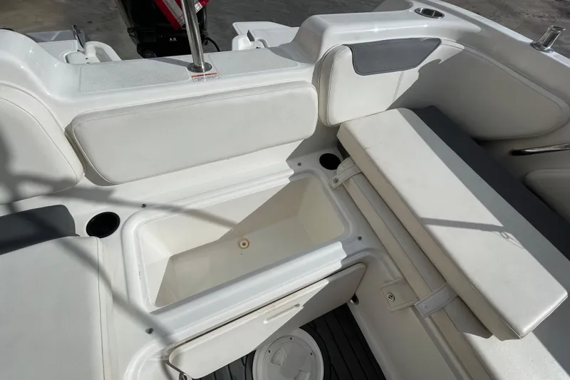 Slide: The Image of 2021 Bayliner Element E21 boat interior with white seating and storage compartment. - 17