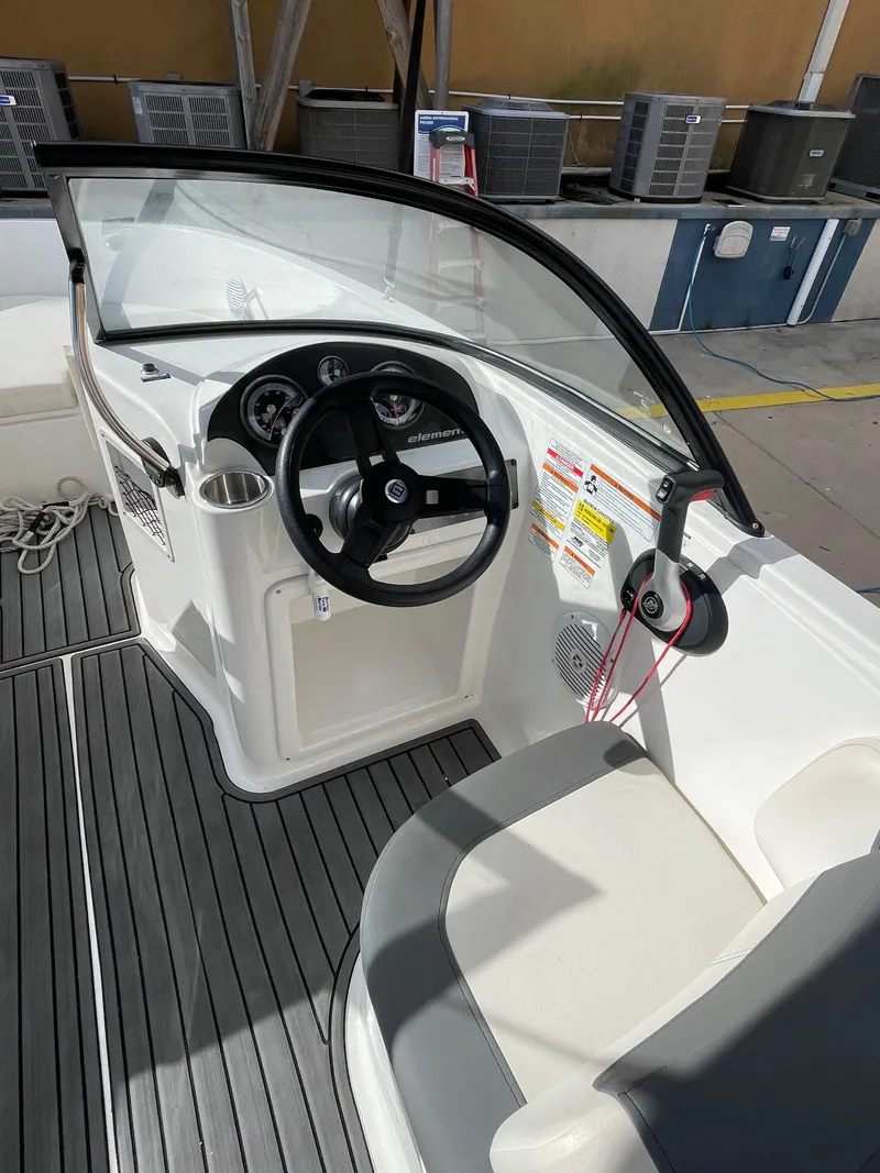Slide: The Image of 2021 Bayliner Element E21 boat cockpit with steering wheel and seating. - 20