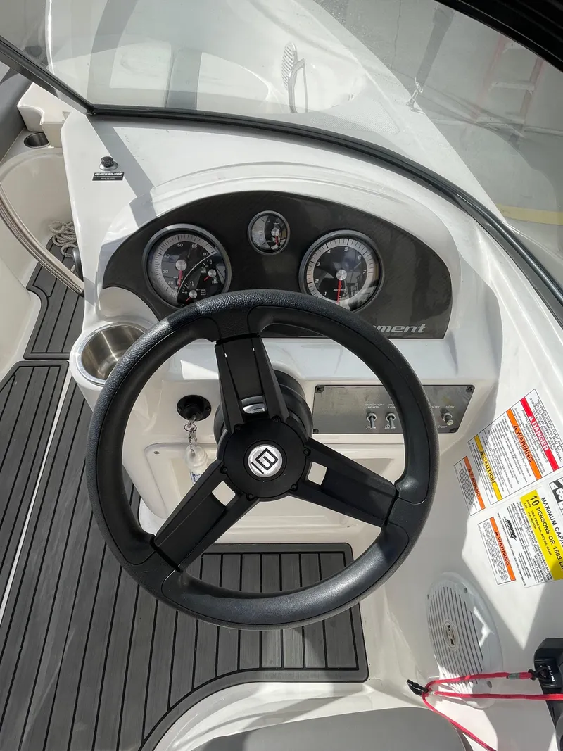 Slide: The Image of 2021 Bayliner Element E21 boat dashboard with steering wheel and gauges. - 21