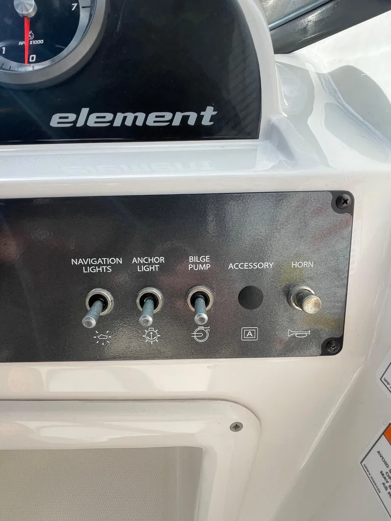 Slide: The Image of Control panel of 2021 Bayliner Element E21 boat with switches for lights, bilge pump, and horn. - 22