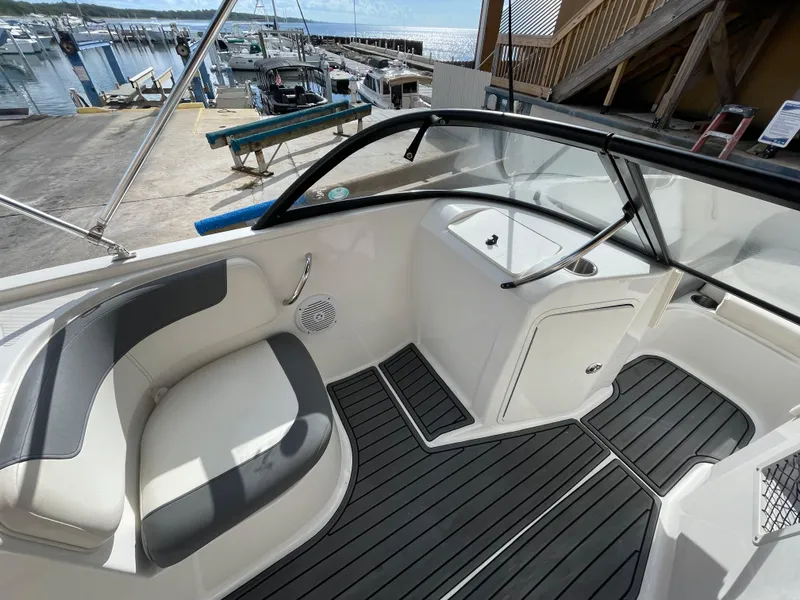 Slide: The Image of 2021 Bayliner Element E21 boat interior with seating and sleek design at a marina. - 24