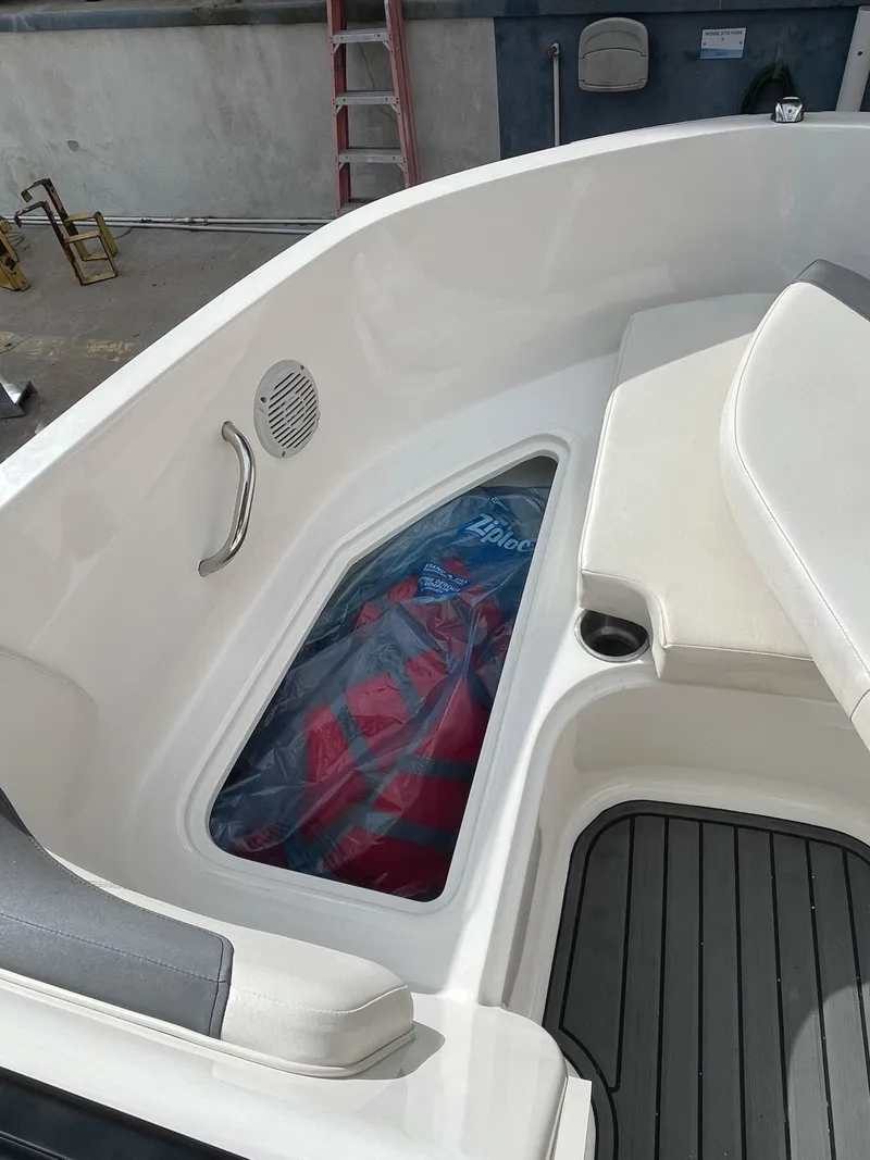 Slide: The Image of 2021 Bayliner Element E21 boat interior with seating and storage compartment. - 27