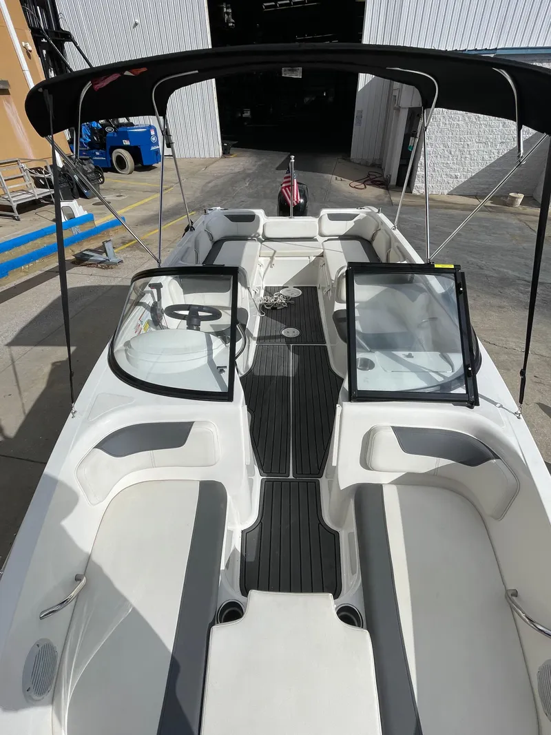 Slide: The Image of 2021 Bayliner Element E21 boat with open deck and seating, docked in a marina. - 29
