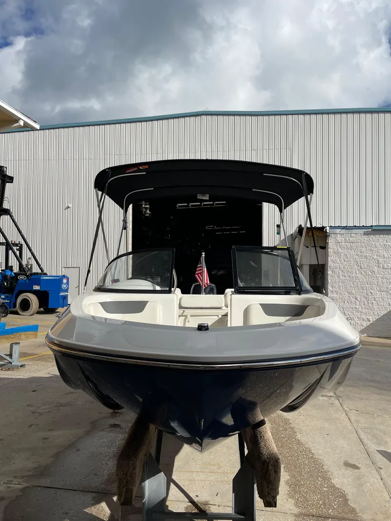 Slide: The Image of 2021 Bayliner Element E21 boat in a marina, under a cloudy sky. - 3