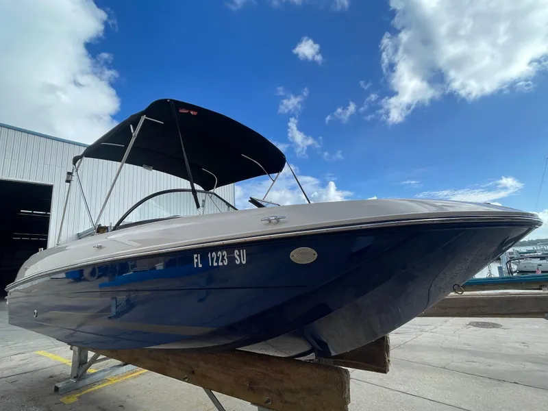 Slide: The Image of 2021 Bayliner Element E21 boat with canopy, docked under a blue sky. - 4