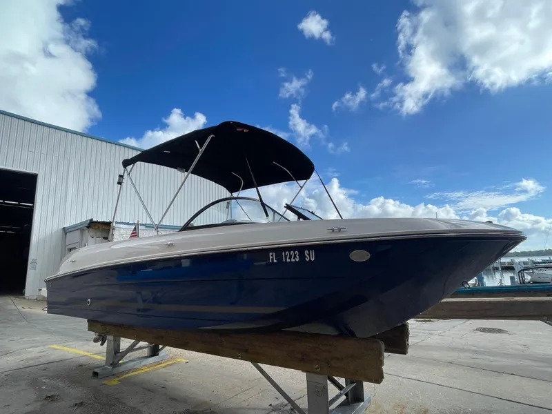 Slide: The Image of 2021 Bayliner Element E21 boat with canopy, docked under a clear blue sky. - 5