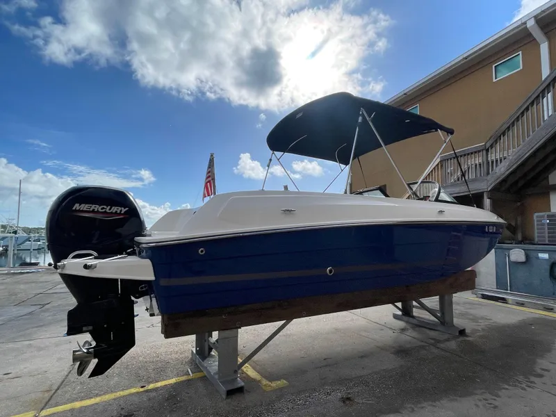 Slide: The Image of 2021 Bayliner Element E21 boat with Mercury engine on a dock under a blue sky. - 6