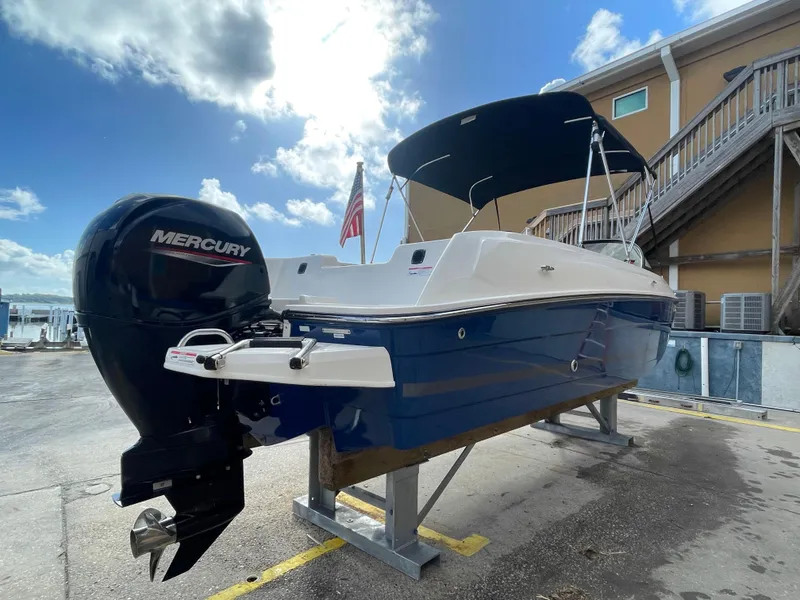 Slide: The Image of 2021 Bayliner Element E21 boat with Mercury engine, docked under a sunny sky. - 7