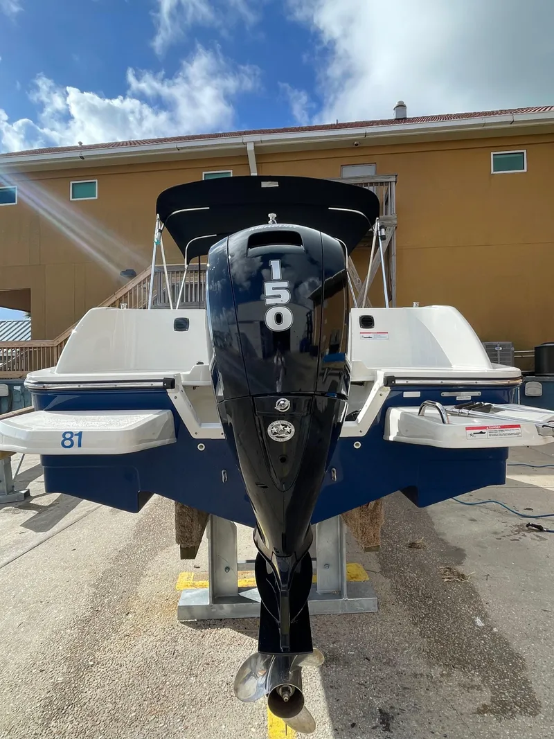 Slide: The Image of 2021 Bayliner Element E21 boat with 150 HP engine, docked outdoors. - 9