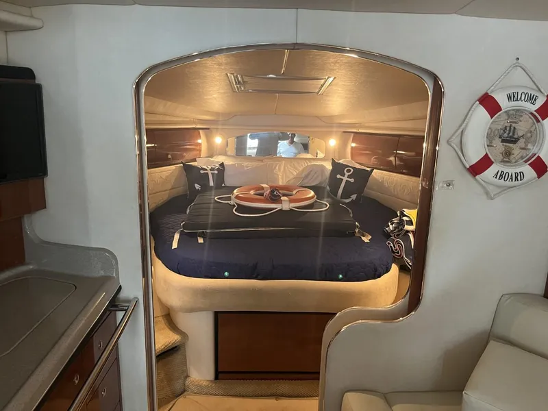 Slide: The Image of 2003 Sea Ray 360 Sundancer cabin interior with cozy bed and nautical decor. - 10
