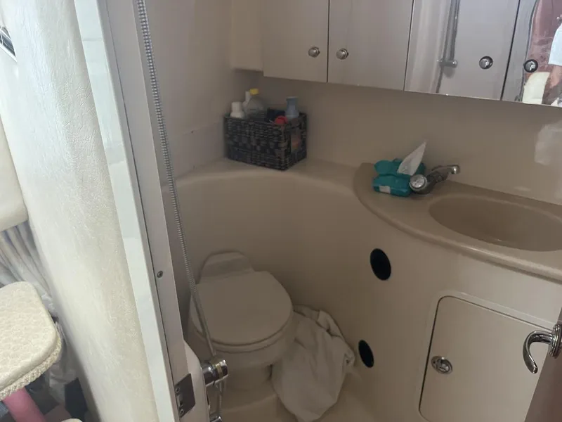 Slide: The Image of 2003 Sea Ray 360 Sundancer bathroom with toilet, sink, and storage cabinets. - 13
