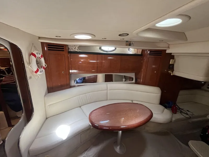 Slide: The Image of Interior of 2003 Sea Ray 360 Sundancer yacht with curved seating and wooden table. - 17