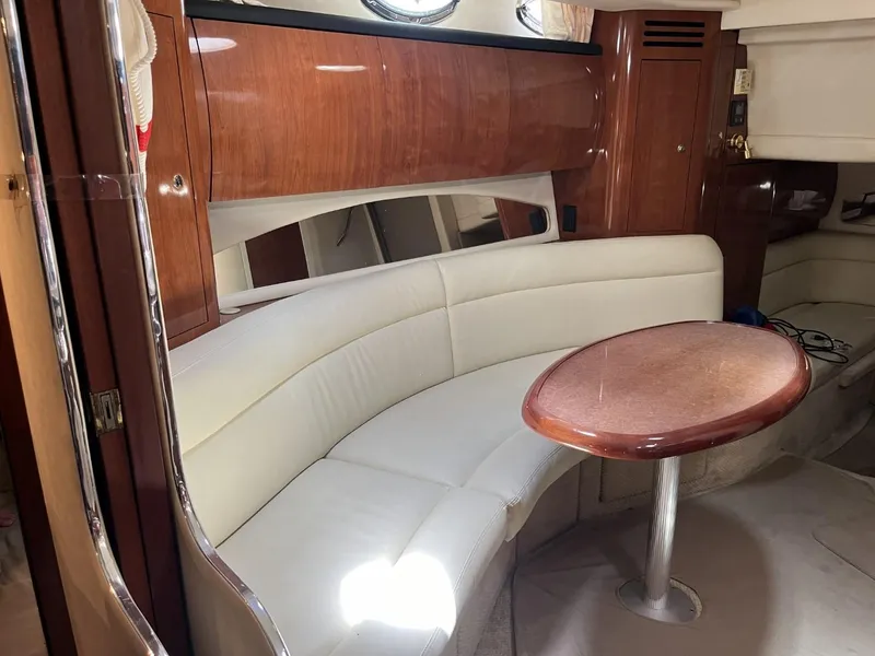 Slide: The Image of Interior of 2003 Sea Ray 360 Sundancer with white leather seating and wooden table. - 18
