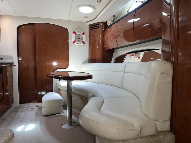 Slide: The Image of Luxurious interior of 2003 Sea Ray 360 Sundancer with white leather seating and wooden accents. - 19
