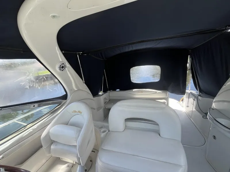 Slide: The Image of 2003 Sea Ray 360 Sundancer interior with white seating and dark canopy. - 34