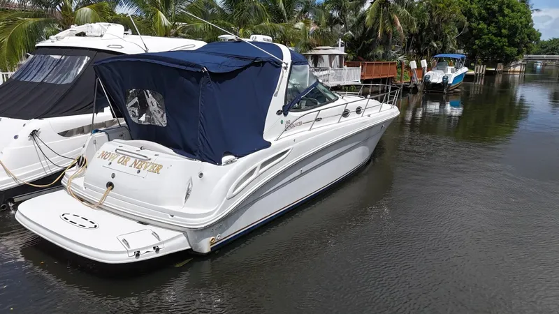 Slide: The Image of 2003 Sea Ray 360 Sundancer yacht docked on a calm waterway, surrounded by lush greenery. - 4