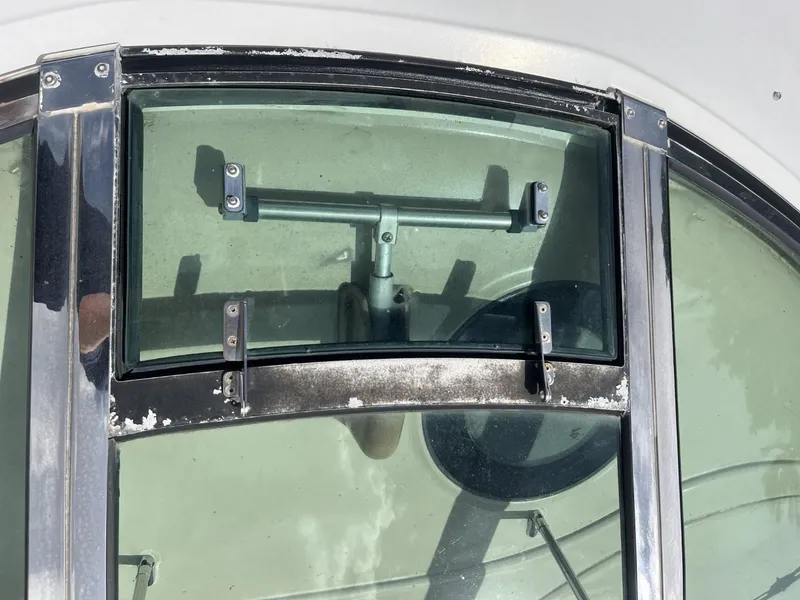 Slide: The Image of Close-up of a 2003 Sea Ray 360 Sundancer window with metal frame and hardware. - 42