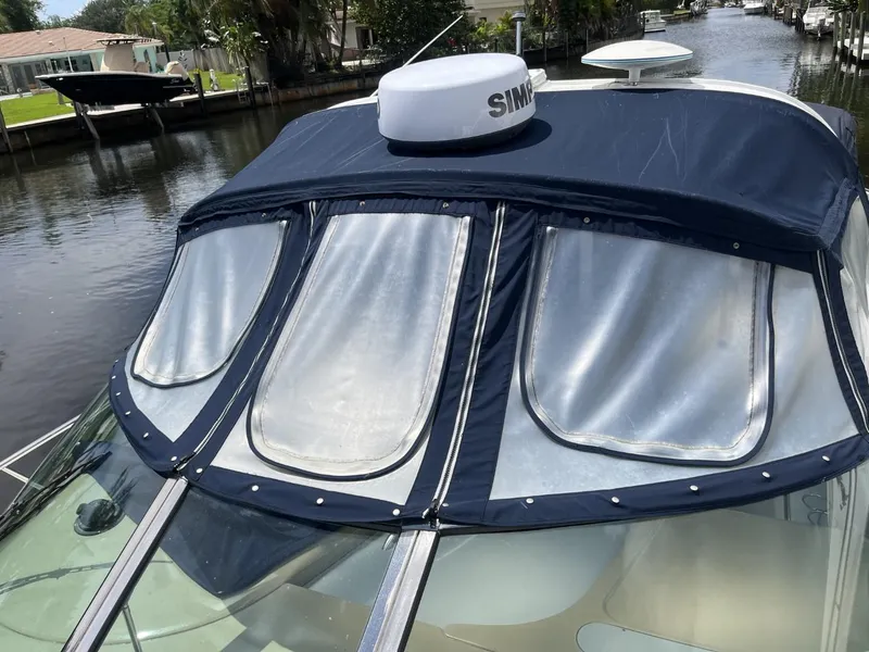 Slide: The Image of 2003 Sea Ray 360 Sundancer with blue canvas cover on a calm canal. - 43