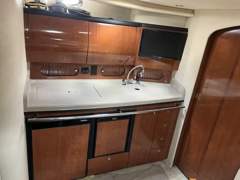 Slide: The Image of 2003 Sea Ray 360 Sundancer interior kitchen with wood cabinets and modern appliances. - 49