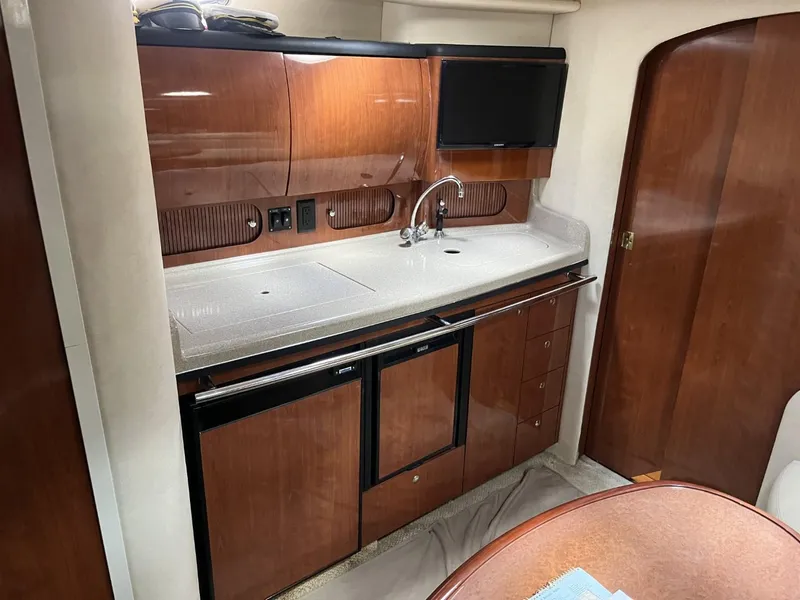 Slide: The Image of 2003 Sea Ray 360 Sundancer interior kitchen with wood cabinetry and modern appliances. - 5