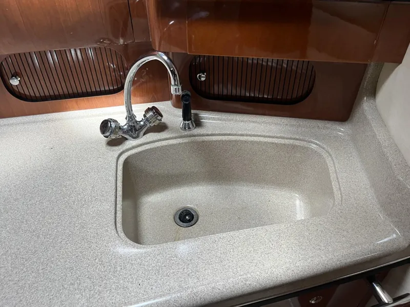 Slide: The Image of 2003 Sea Ray 360 Sundancer kitchen sink with modern faucet and wooden cabinetry. - 7