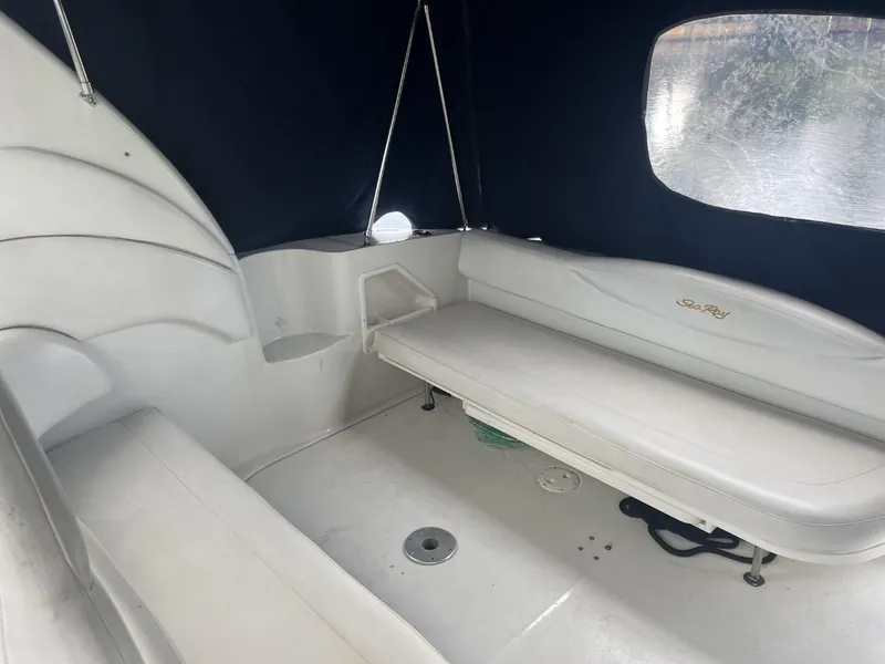 Slide: The Image of 2003 Sea Ray 360 Sundancer interior with white seating and dark canopy. - 8