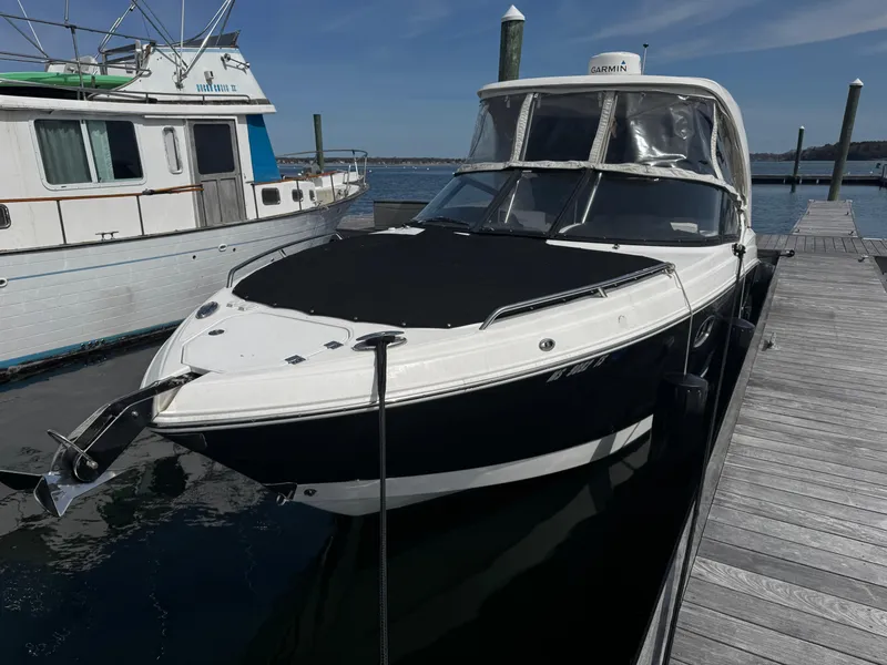 Slide: The Image of 2018 Chaparral 307 SSX boat docked at a marina, featuring sleek design and black hull. - 0