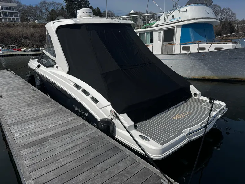 Slide: The Image of 2018 Chaparral 307 SSX boat docked with black cover, side view. - 1
