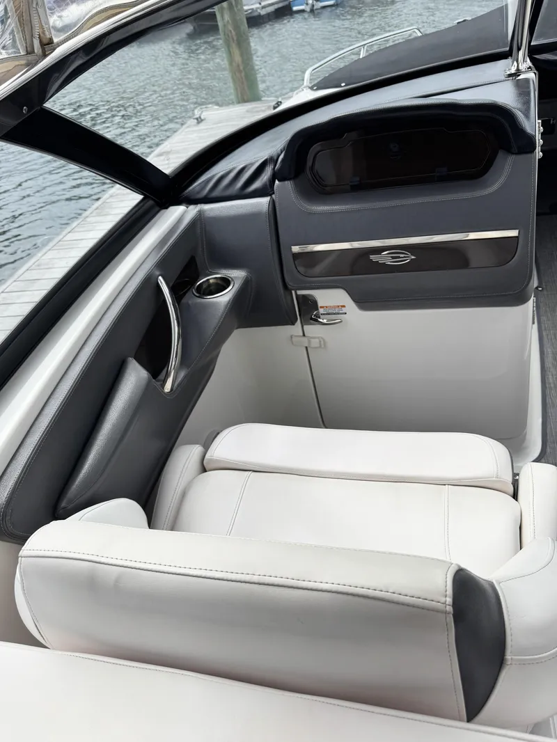 Slide: The Image of 2018 Chaparral 307 SSX boat interior with white seating and sleek dashboard design. - 10