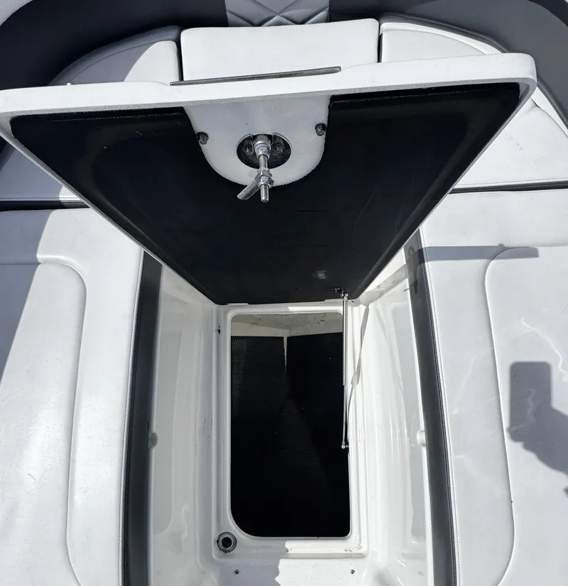 Slide: The Image of Open storage compartment on 2018 Chaparral 307 SSX boat, featuring sleek white interior design. - 19