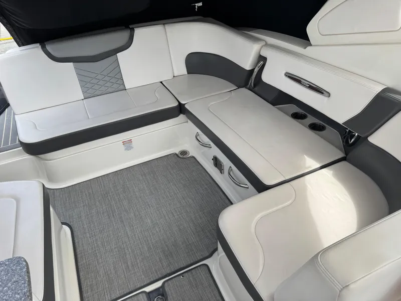 Slide: The Image of 2018 Chaparral 307 SSX boat interior with gray and white seating and carpeted flooring. - 5