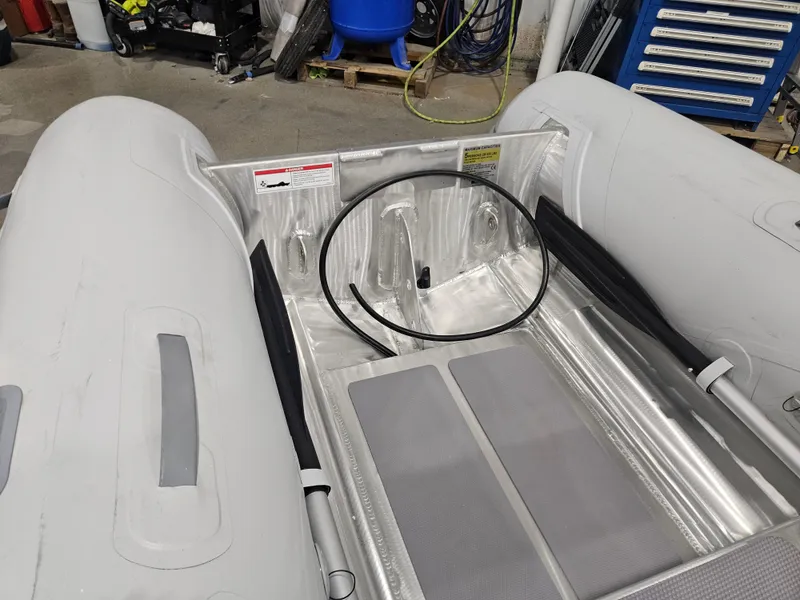 Slide: The Image of 2024 AB Inflatables Lammina 9.5 AL boat interior with oars and aluminum flooring. - 11