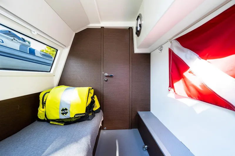 Slide: The Image of Cozy cabin interior of 2020 Prestige 520 Fly yacht with a bed, window, and flag. - 28