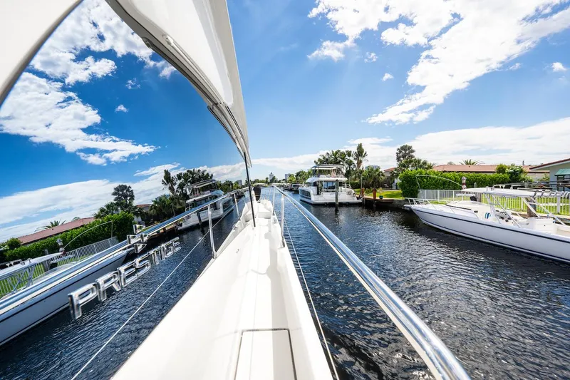 Slide: The Image of 2020 Prestige 520 Fly yacht cruising on a sunny day, reflecting blue skies and clouds. - 4