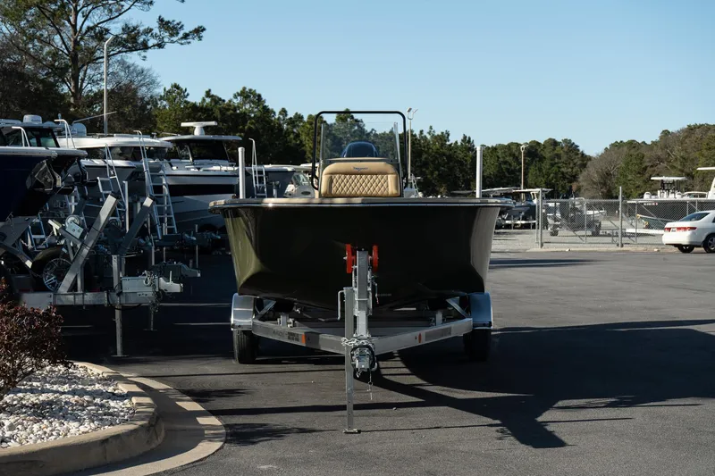 Slide: The Image of 2025 Savannah SS21 Duck boat on trailer in parking lot, surrounded by trees and other boats. - 6