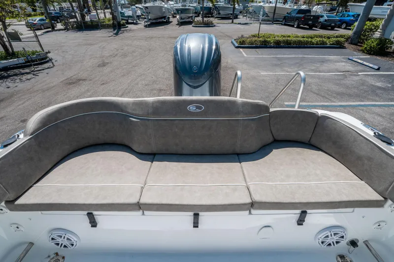Slide: The Image of Rear seating area of 2025 Sea Hunt Ultra 229 boat, featuring cushioned bench and motor. - 10