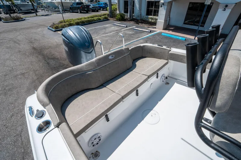 Slide: The Image of 2025 Sea Hunt Ultra 229 boat interior with cushioned seating and Yamaha engine in a parking lot. - 11