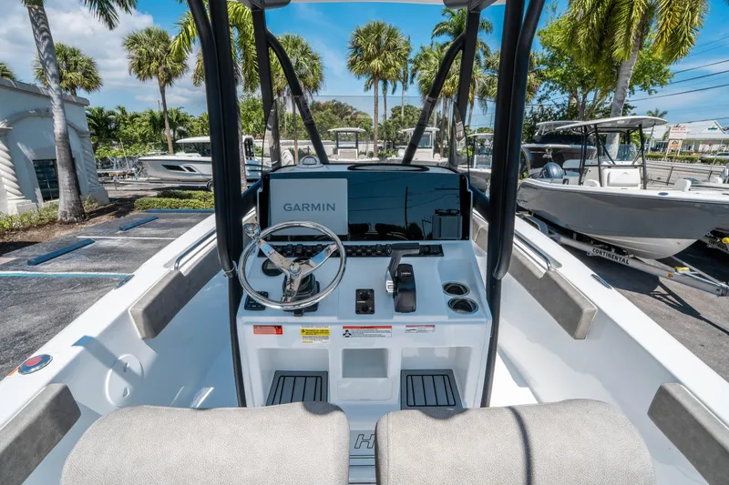 Slide: The Image of 2025 Sea Hunt Ultra 229 boat interior with Garmin navigation, parked under palm trees. - 14