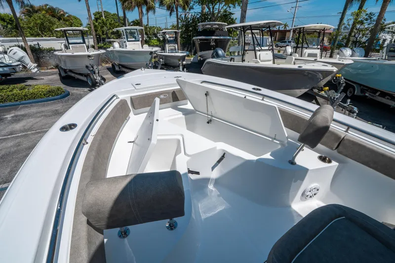 Slide: The Image of 2025 Sea Hunt Ultra 229 boat interior with seating and storage, displayed in a marina. - 21