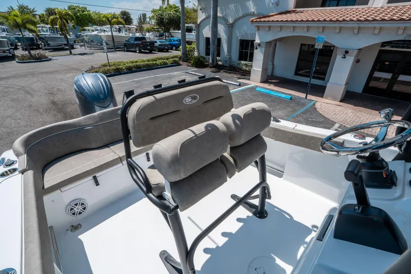 Slide: The Image of 2025 Sea Hunt Ultra 229 boat interior with dual seats and steering wheel, parked outdoors. - 16