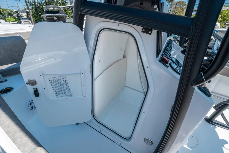 Slide: The Image of 2025 Sea Hunt Ultra 229 boat interior storage compartment with open door. - 18