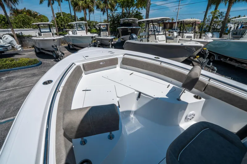 Slide: The Image of 2025 Sea Hunt Ultra 229 boat interior with seating, surrounded by other boats. - 20