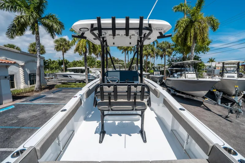 Slide: The Image of 2025 Sea Hunt Ultra 229 boat in a sunny marina with palm trees. - 9