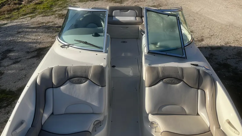 Slide: The Image of 2002 Sea Ray 270 Sundeck boat interior with beige seating and open windshield. - 12