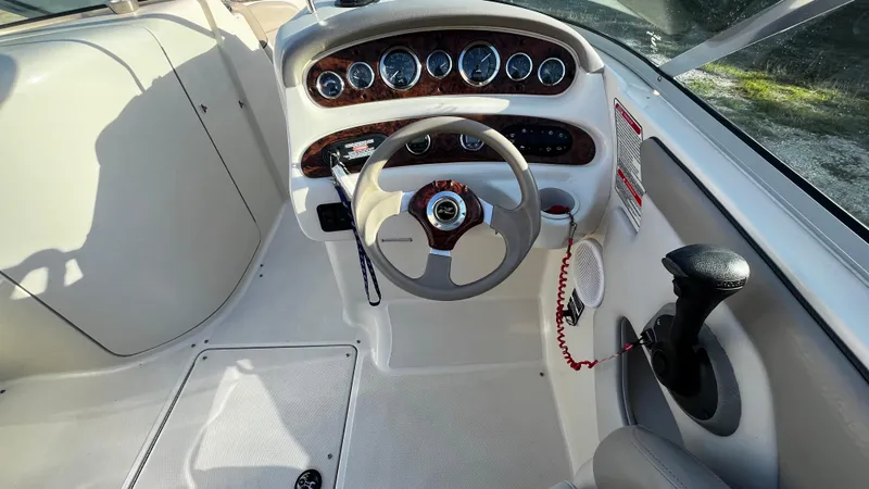 Slide: The Image of 2002 Sea Ray 270 Sundeck boat interior with beige seating and cup holders. - 9