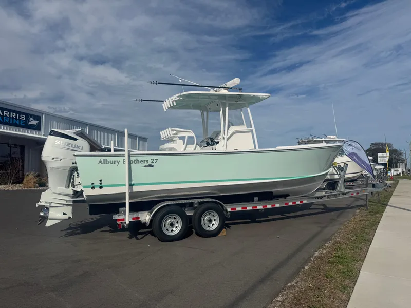 Slide: The Image of 2023 Albury Brothers 27 boat on trailer, parked outdoors under a cloudy sky. - 1