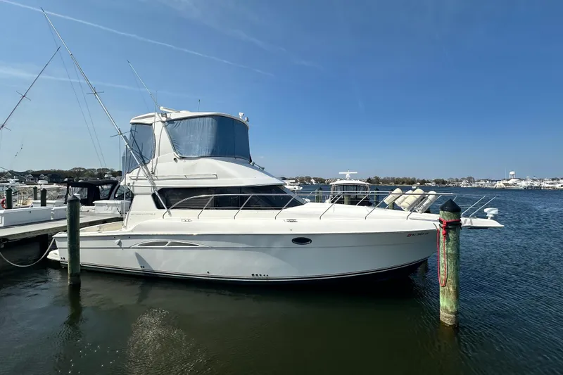 Slide: The Image of 2006 Silverton 42 Convertible yacht docked at marina under clear blue sky. - 10