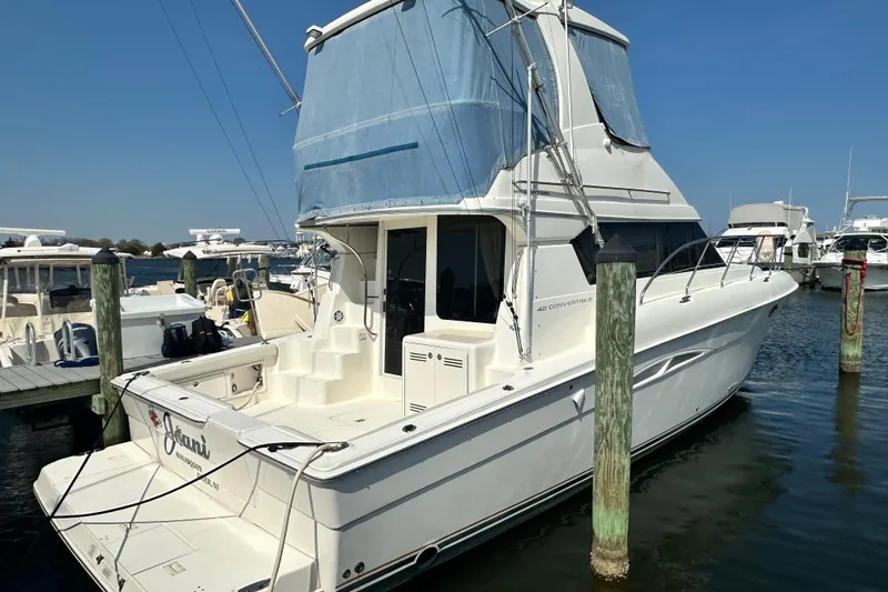 Slide: The Image of 2006 Silverton 42 Convertible yacht docked at marina, clear blue sky. - 12