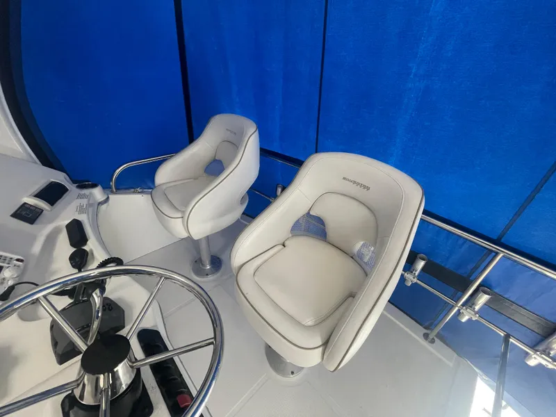 Slide: The Image of 2006 Silverton 42 Convertible helm with two white captain chairs and blue backdrop. - 15